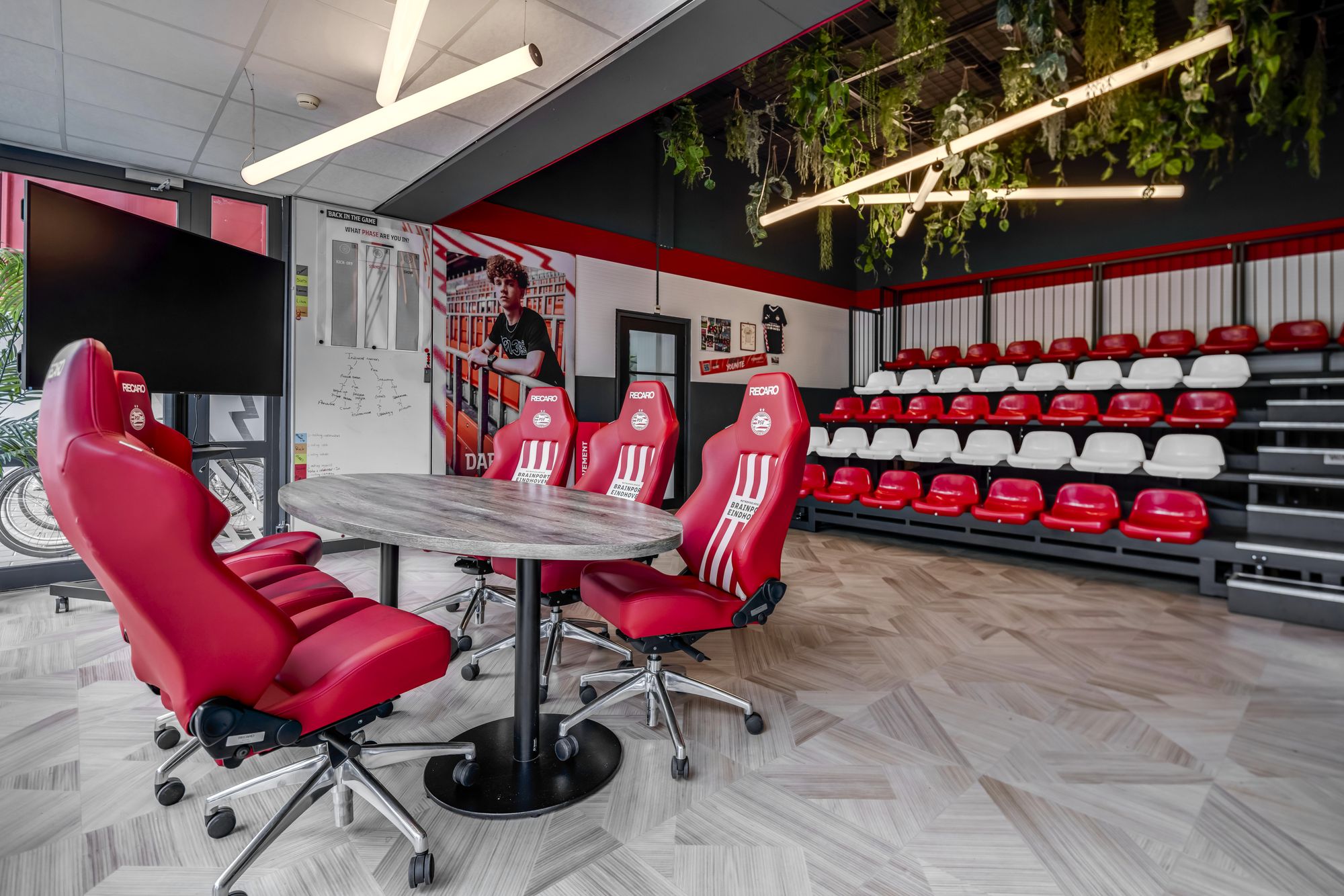 Tafel met rode stoelen en de tribune in de jongerenruimte